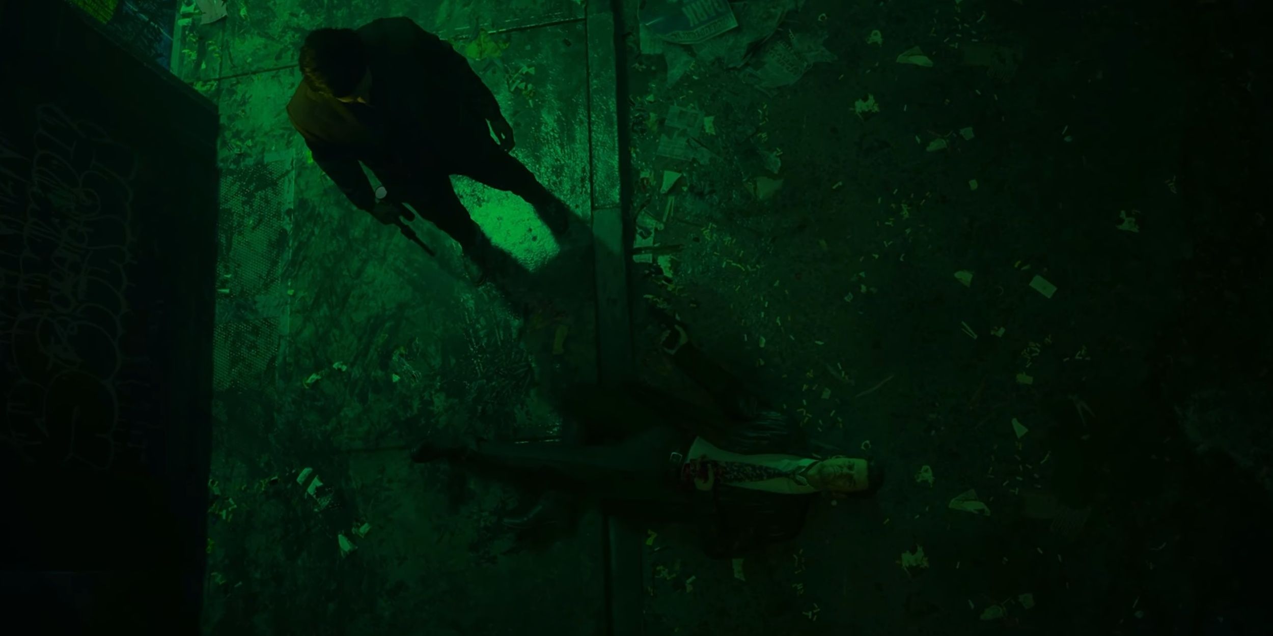 Alex Casey lies shot on the pavement. Alan Wake stands over him, holding a gun