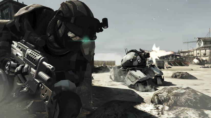 Ghost Recon Future Soldier player taking cover while a futuristic tank fires off-screen.