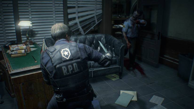 Leon attacks a police zombie with a knife.