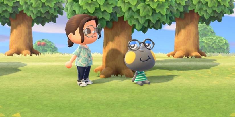 Huck sits under a tree while a villager stands beside him in Animal Crossing New Horizons.