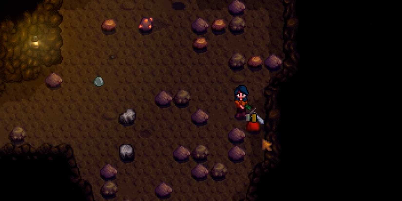 player in mines attacking a slime with a sword in Stardew Valley