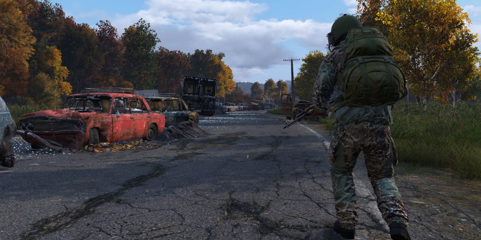 In-game Screenshot of an abandoned road with destroyed cars in DayZ.