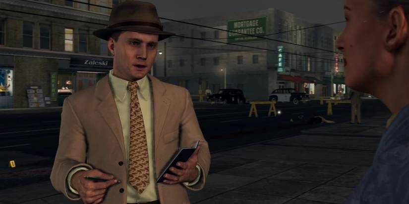 Cole Phelps interviews a witness at a crime scene as part of his LA Noire investigation.