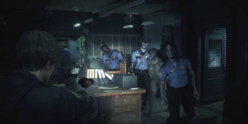 Leon aiming his gun and flashlight at a group of RCPD zombies inside the police station, who are roaming toward him fast.