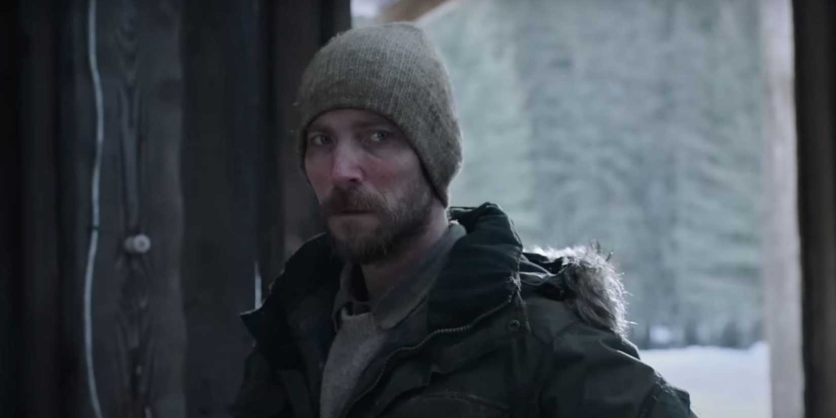 Troy Baker, wearing a beanie as his villainous character James in HBO's The Last of Us, walks through the door.