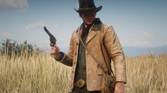 A Mod For Red Dead Redemption 2 that updates the graphics of Arhtur's gunslinger coat, with a photo that showcases Arthur wearing the tan coat in a field.