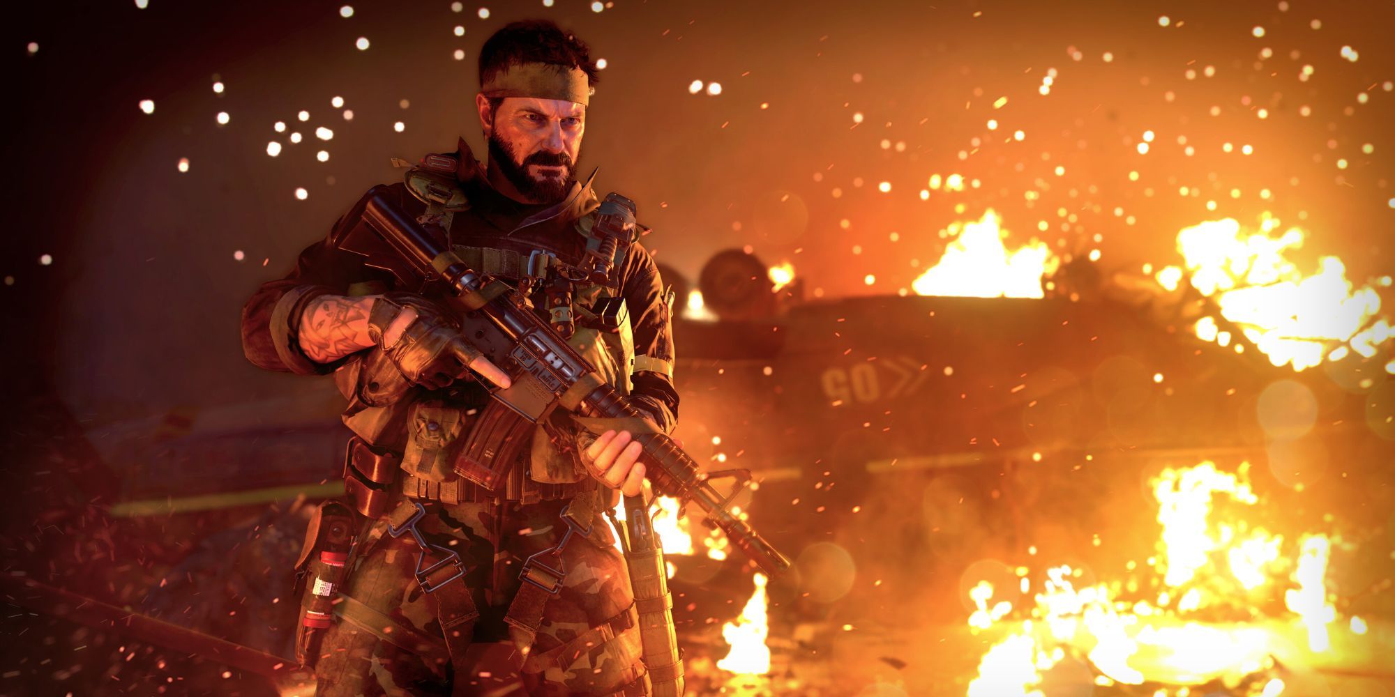 Frank Woods holding an assault rifle against a burning vehicle in Call of Duty: Black Ops Cold War.