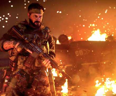 Frank Woods holding an assault rifle on the background of burning vehicles in Call of Duty: Black Ops Cold War.