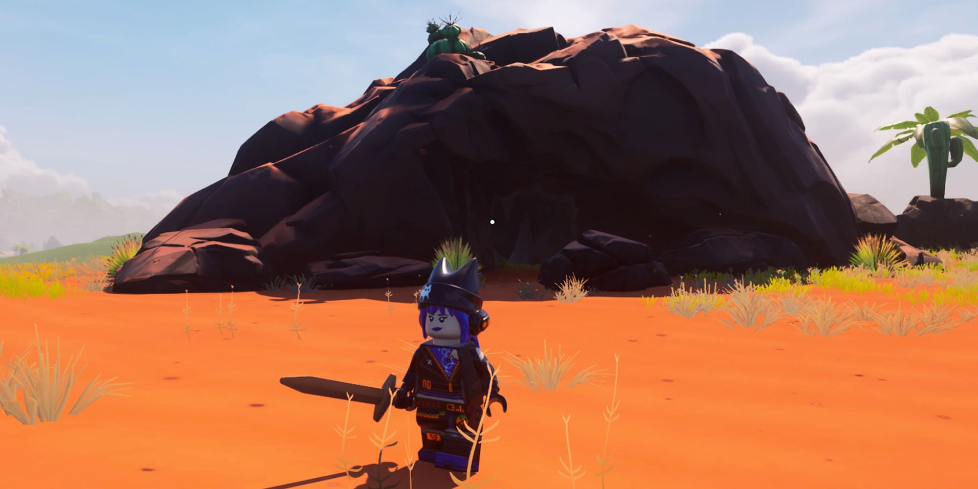 A player in front of a cave in the desert biome in Lego Fortnite.