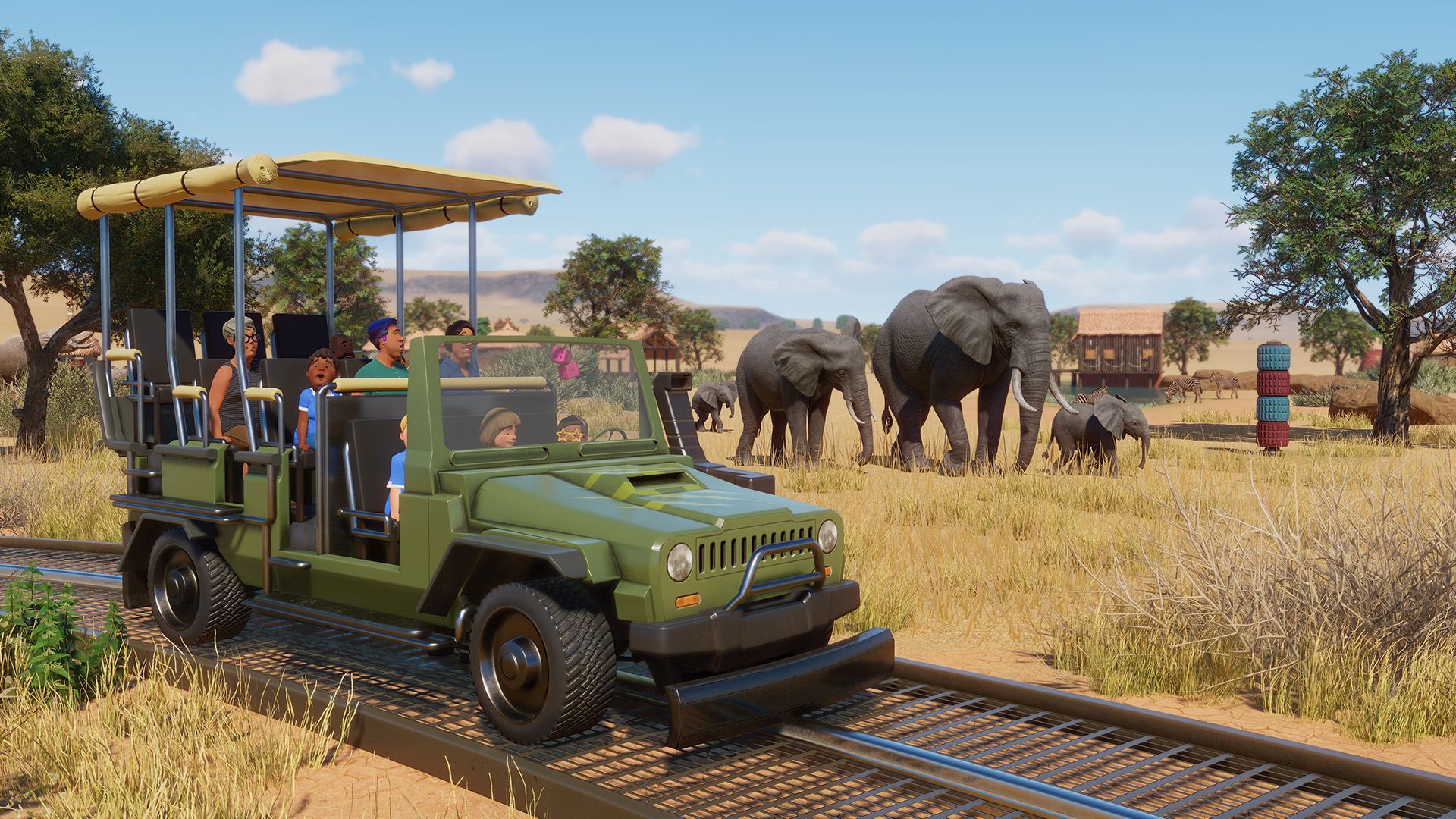 Planet Zoo screenshot showing a jeep driving past some elephants 