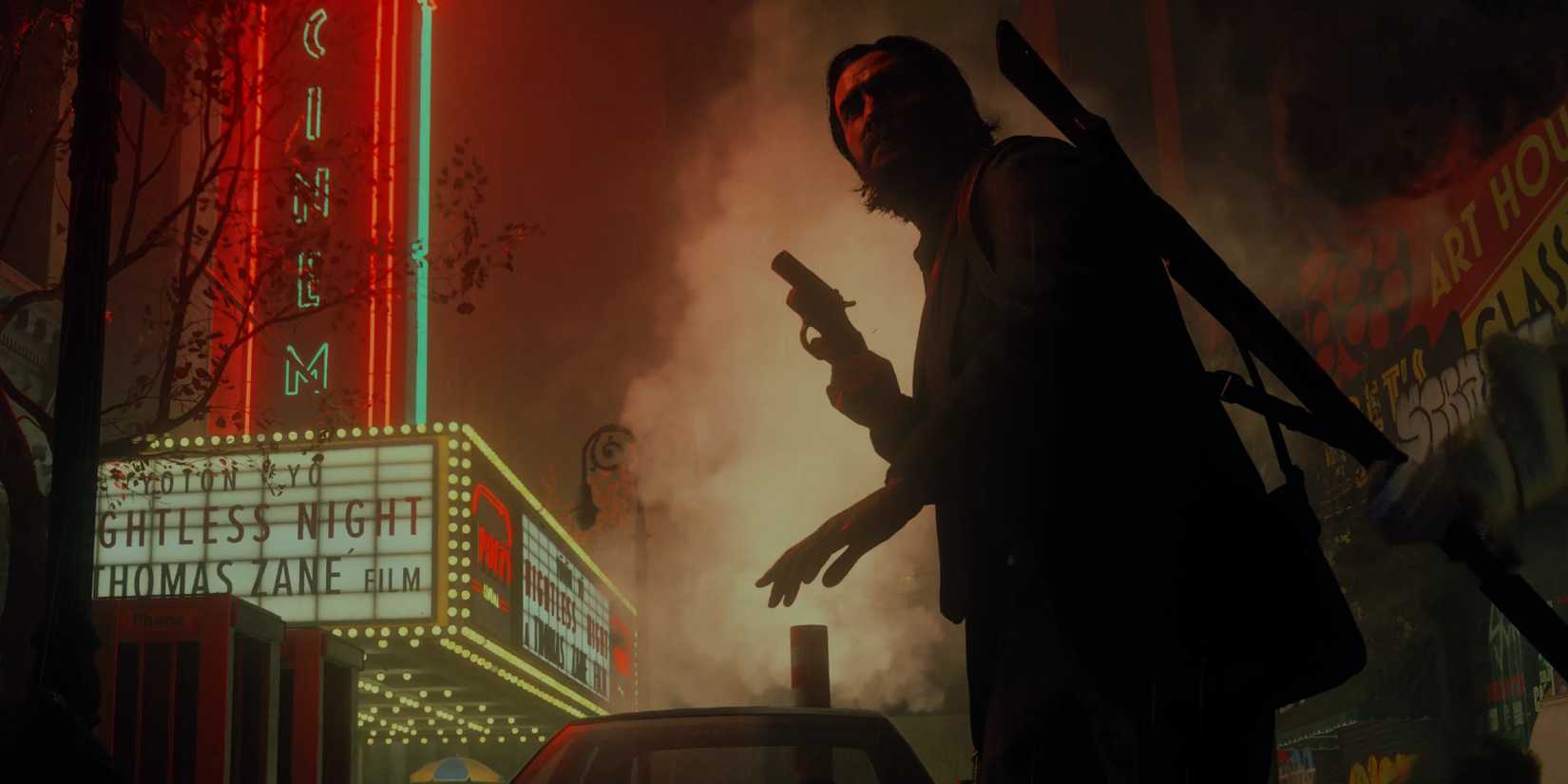 Alan Wake 2 on a very dark street with a glowing cinema building in the background