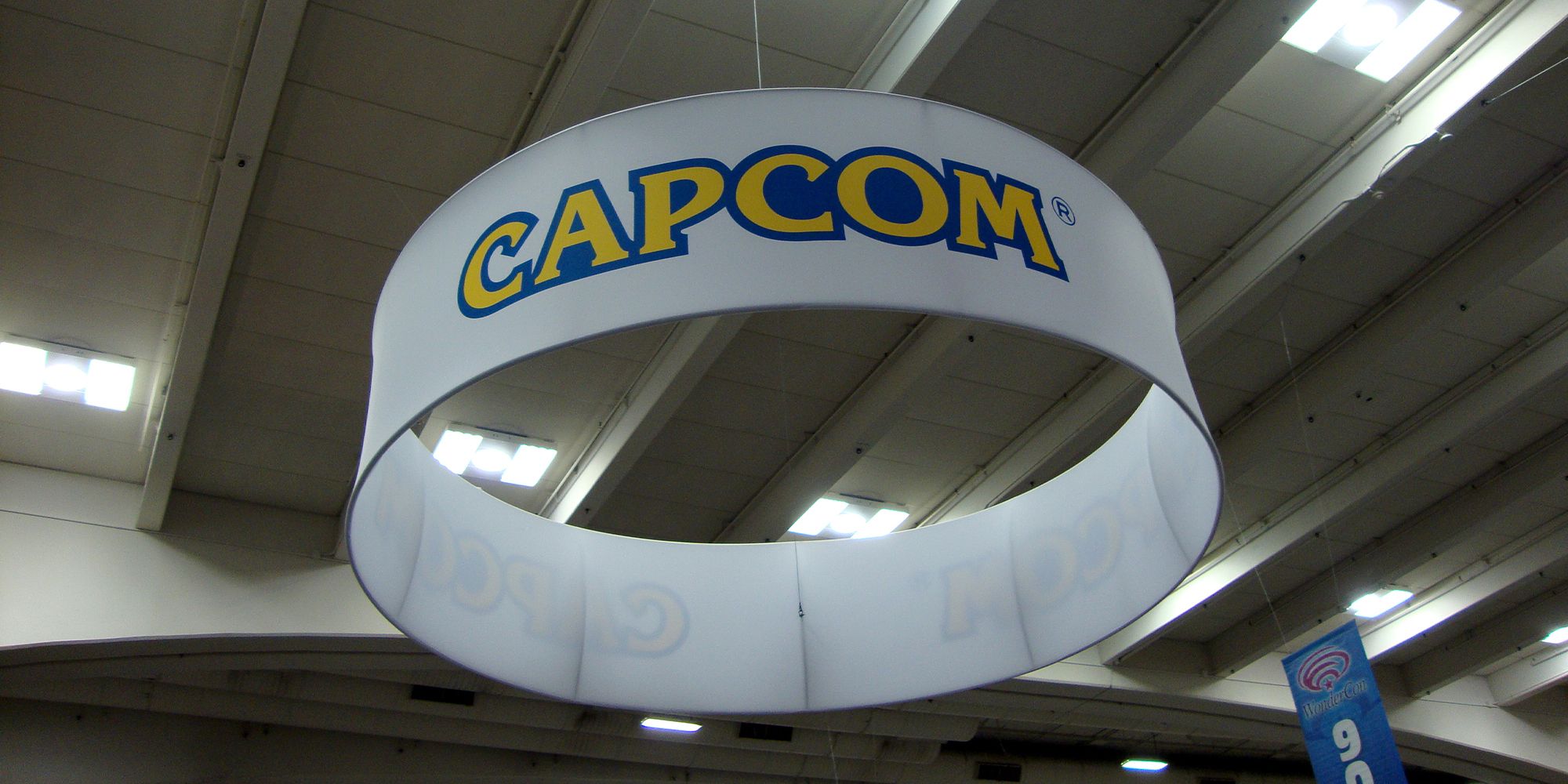 NEWS Capcom logo hanging in a hall on a white cylindrical object