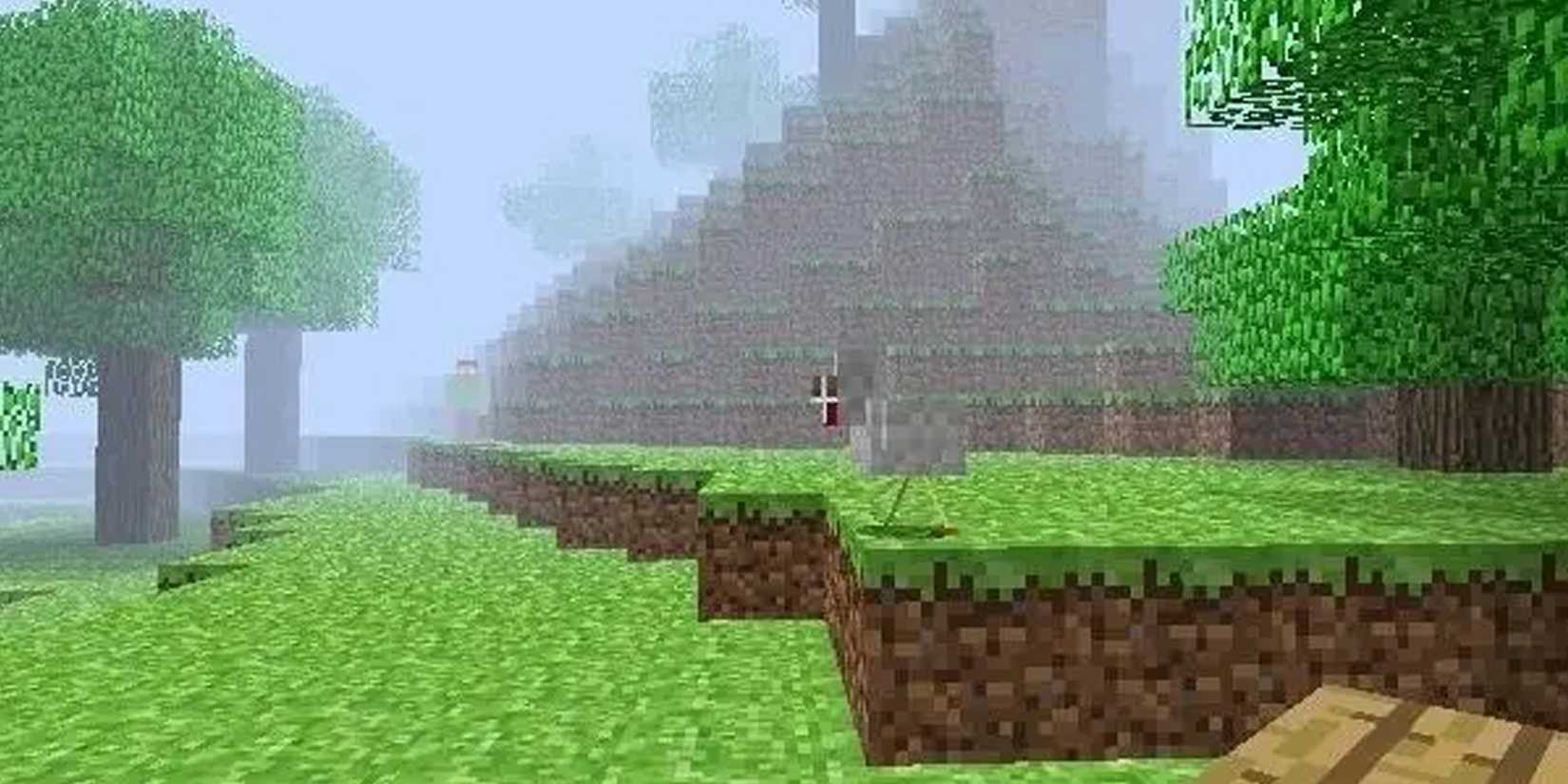 Original screenshot of Herobrine in Minecraft, he stands in the fog watchingg the player at the bottom of a hill by oak trees