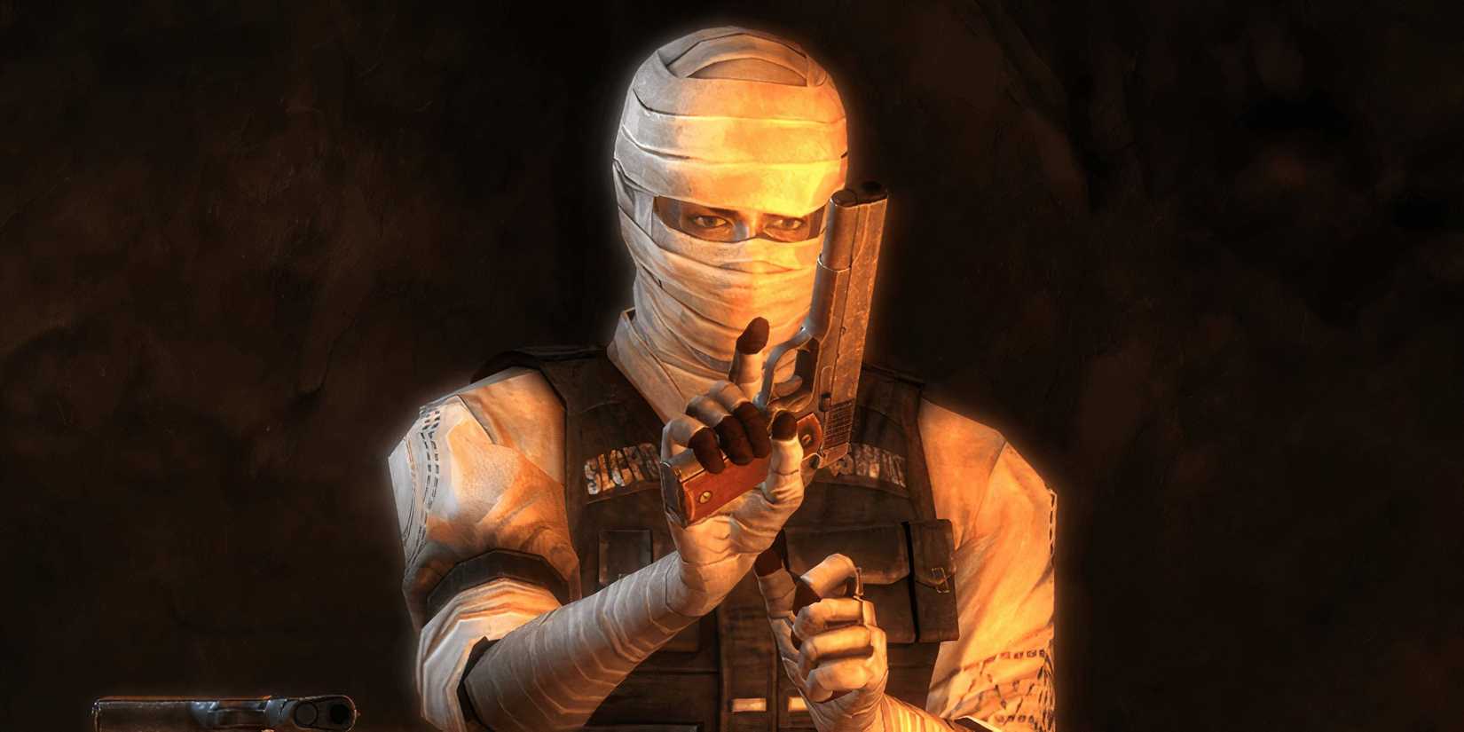 Joshua Graham, a man in bandages, holds a gun in Fallout: New Vegas.
