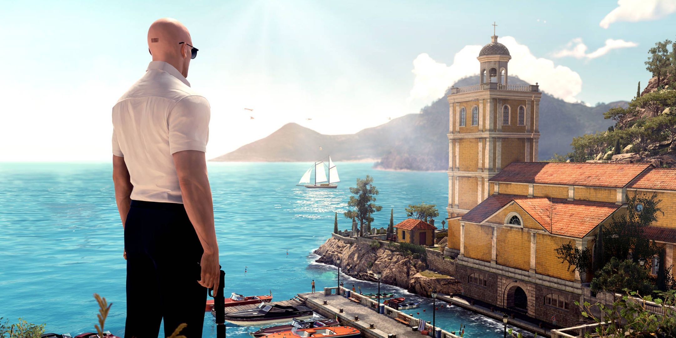 Agent 47 looks out at Sapienza in Hitman. 