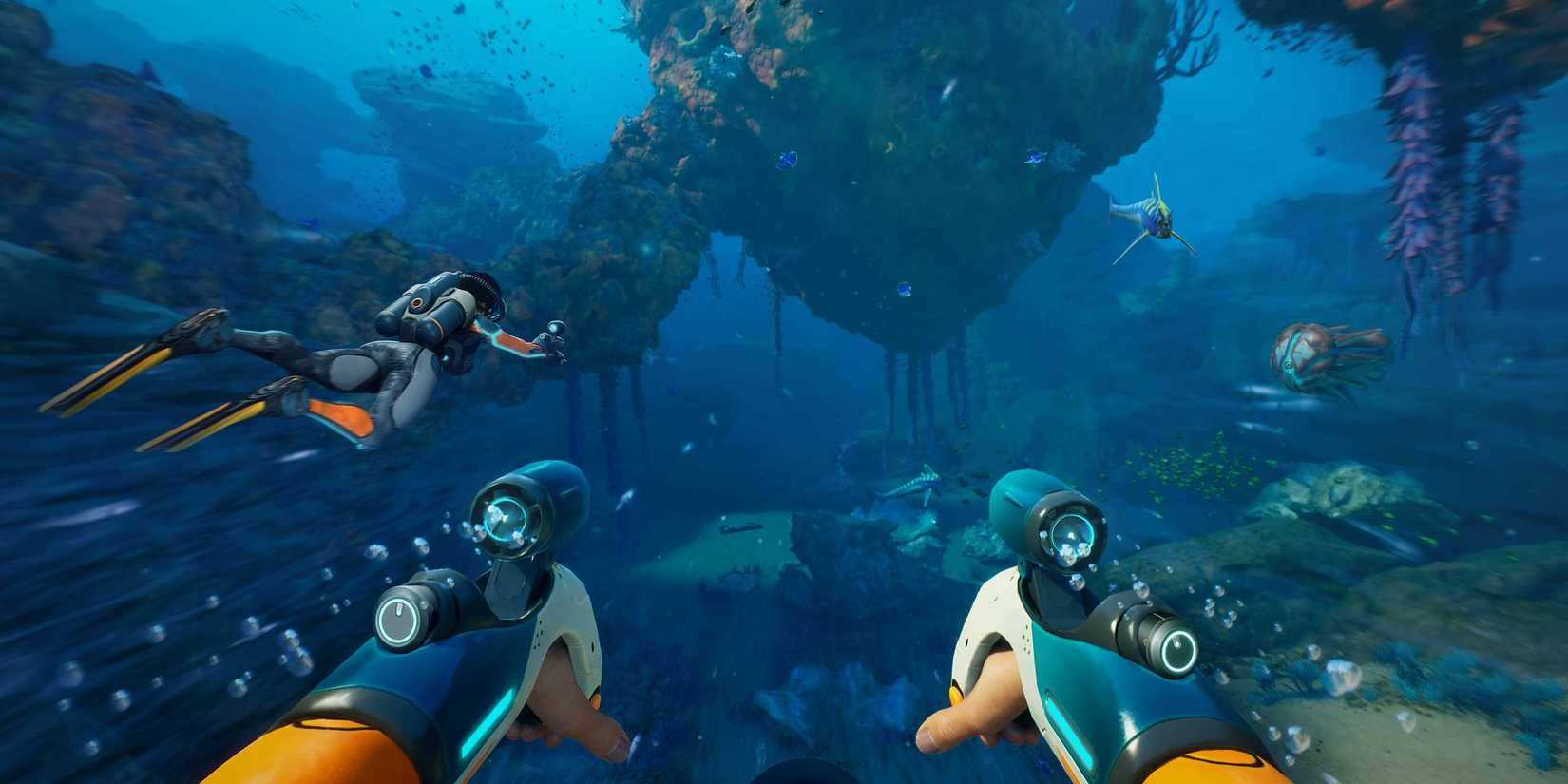Subnautica - Players swim together with some fish.