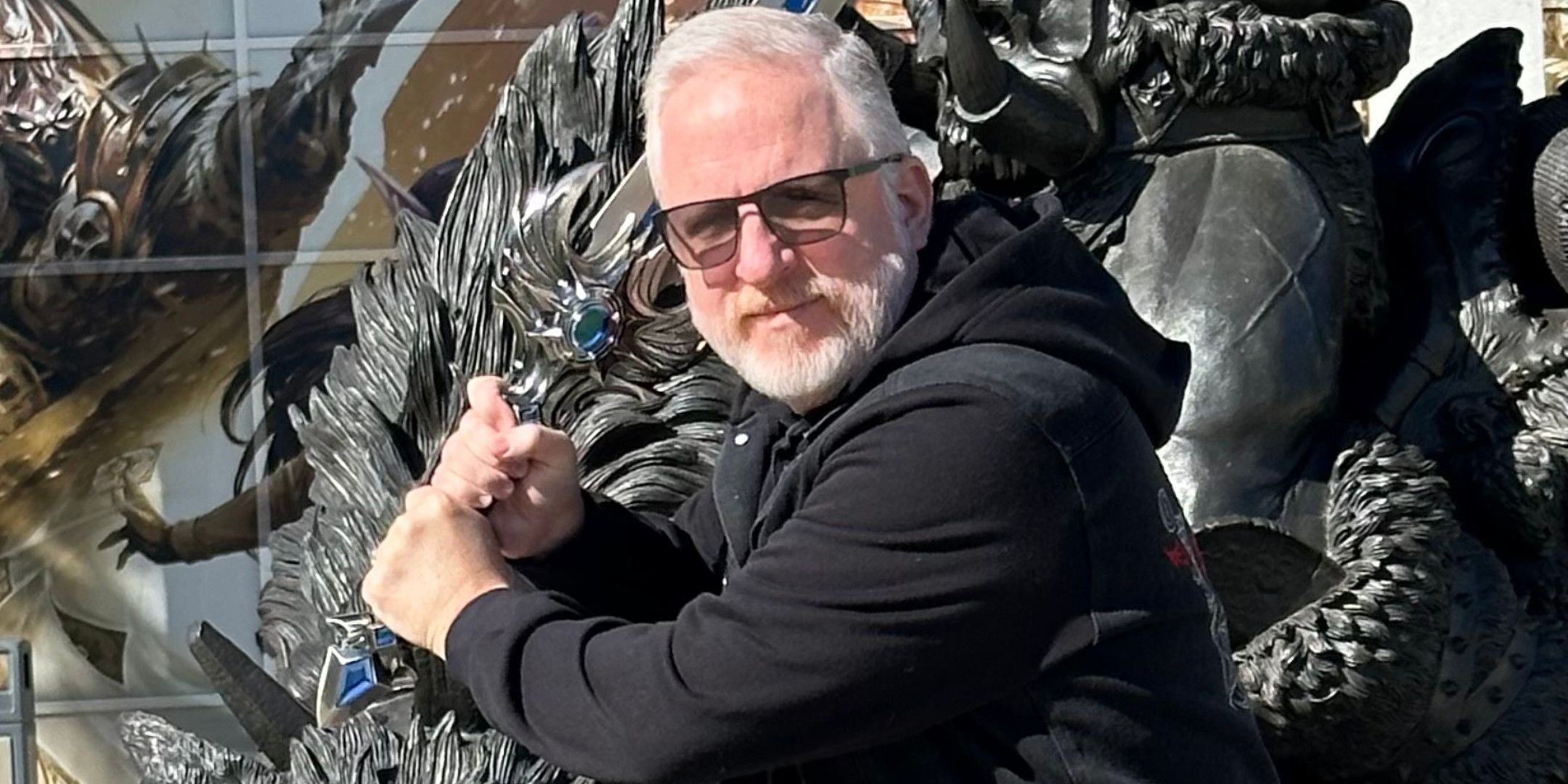 A man with white hair wielding a large sword.