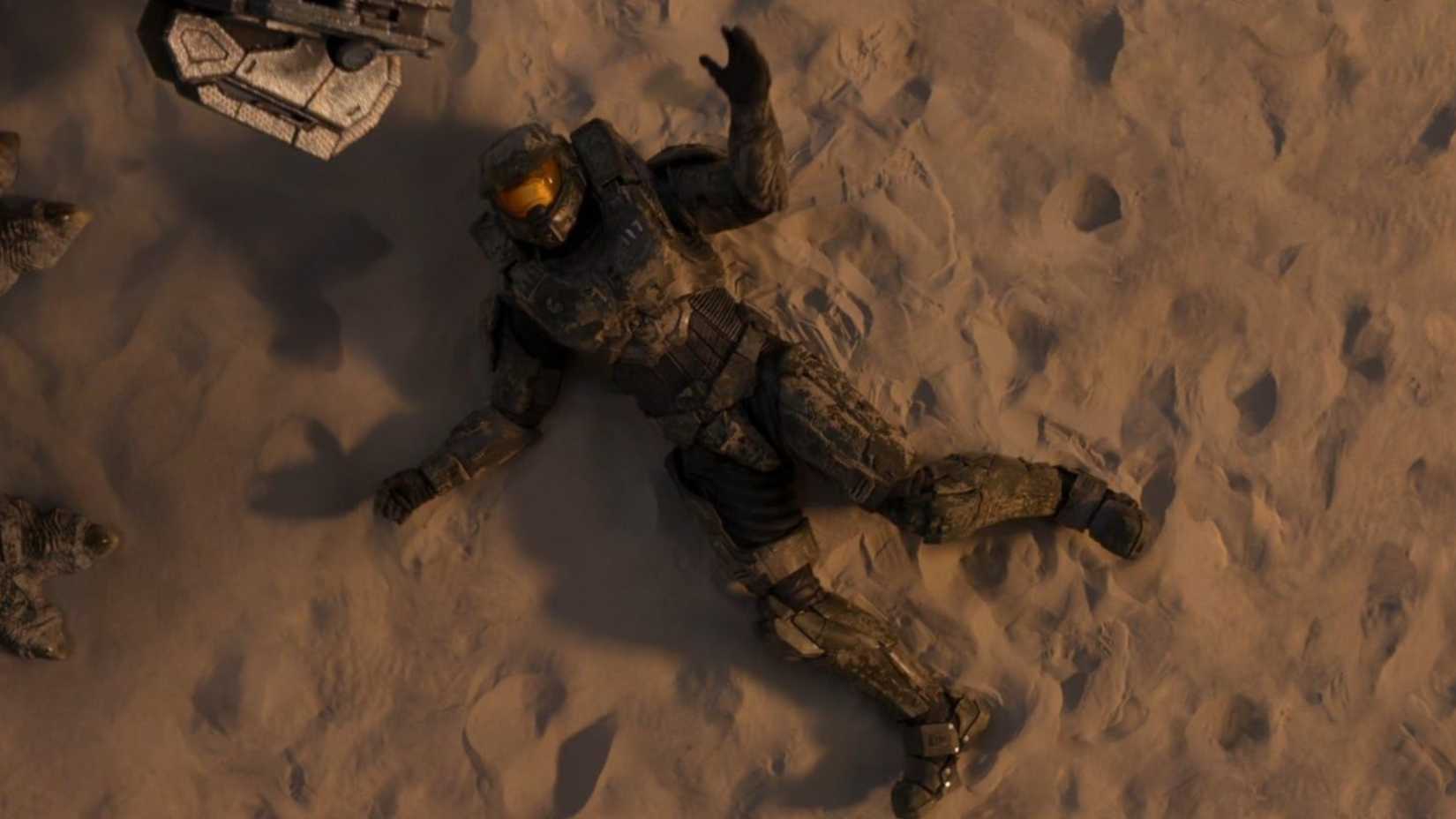 master chief lying in the sand in the halo tv show.