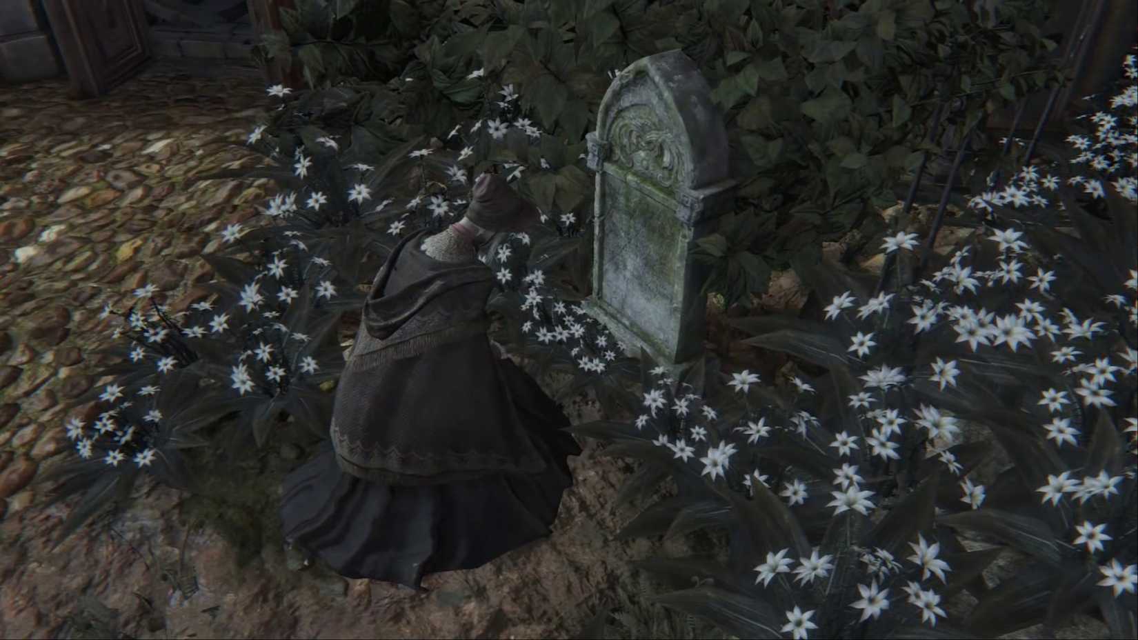 The Doll kneeling and praying at a tombstone in Bloodborne.