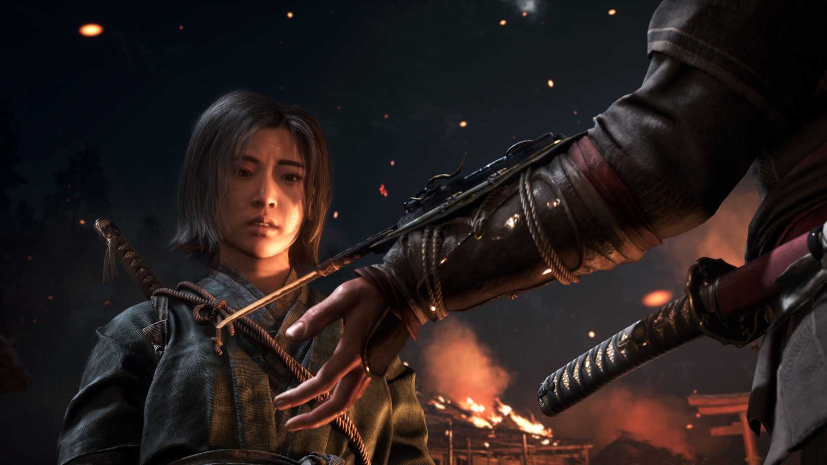 A screenshot from Assassins Creed Shadows, showing a female assassin looking at another assassin's blade coming from their sleeve.