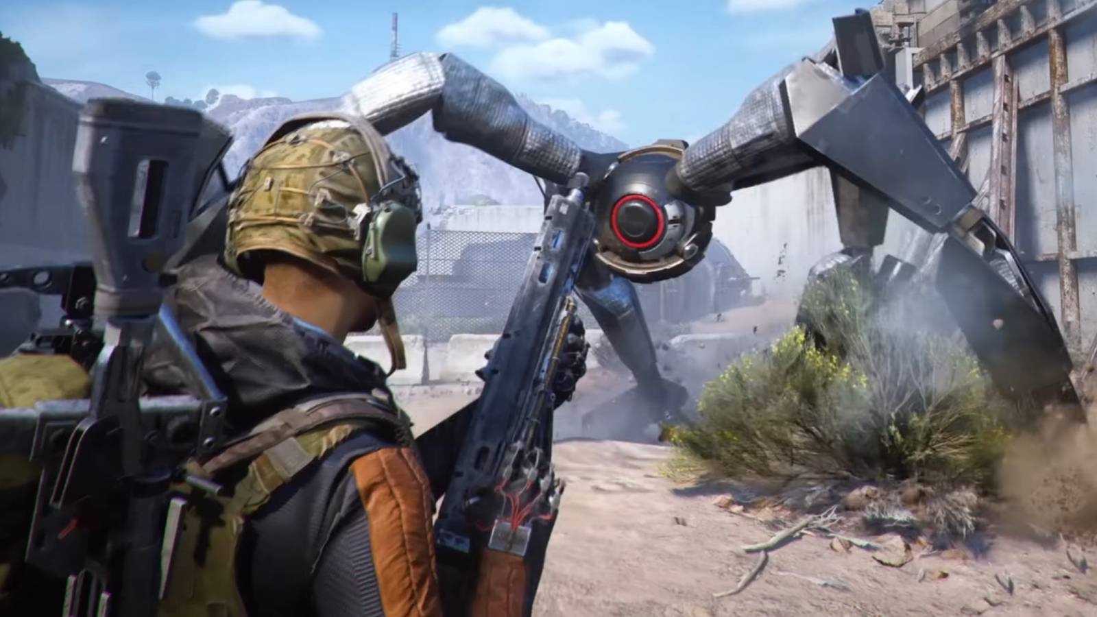 A man with a gun looking at a large robot walking on four legs.