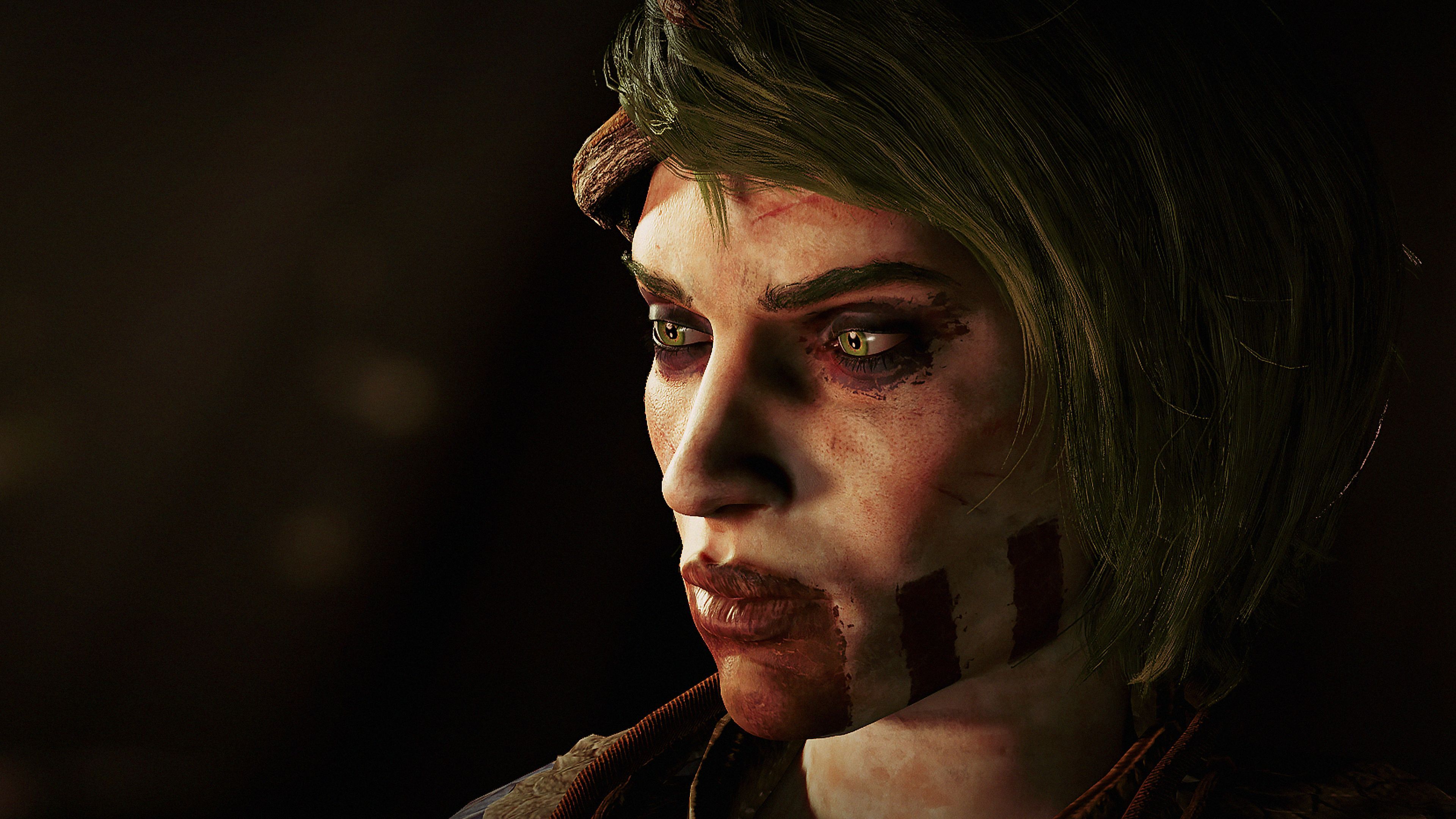 A screenshot of GreedFall The Dying World, showing a close up of a woman's face. She has war paint on her face and short hair.