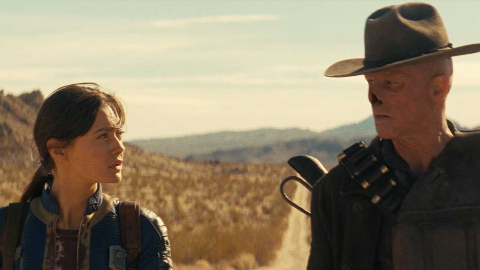 Lucy and The Ghoul from Fallout are shown walking through the Mojave.