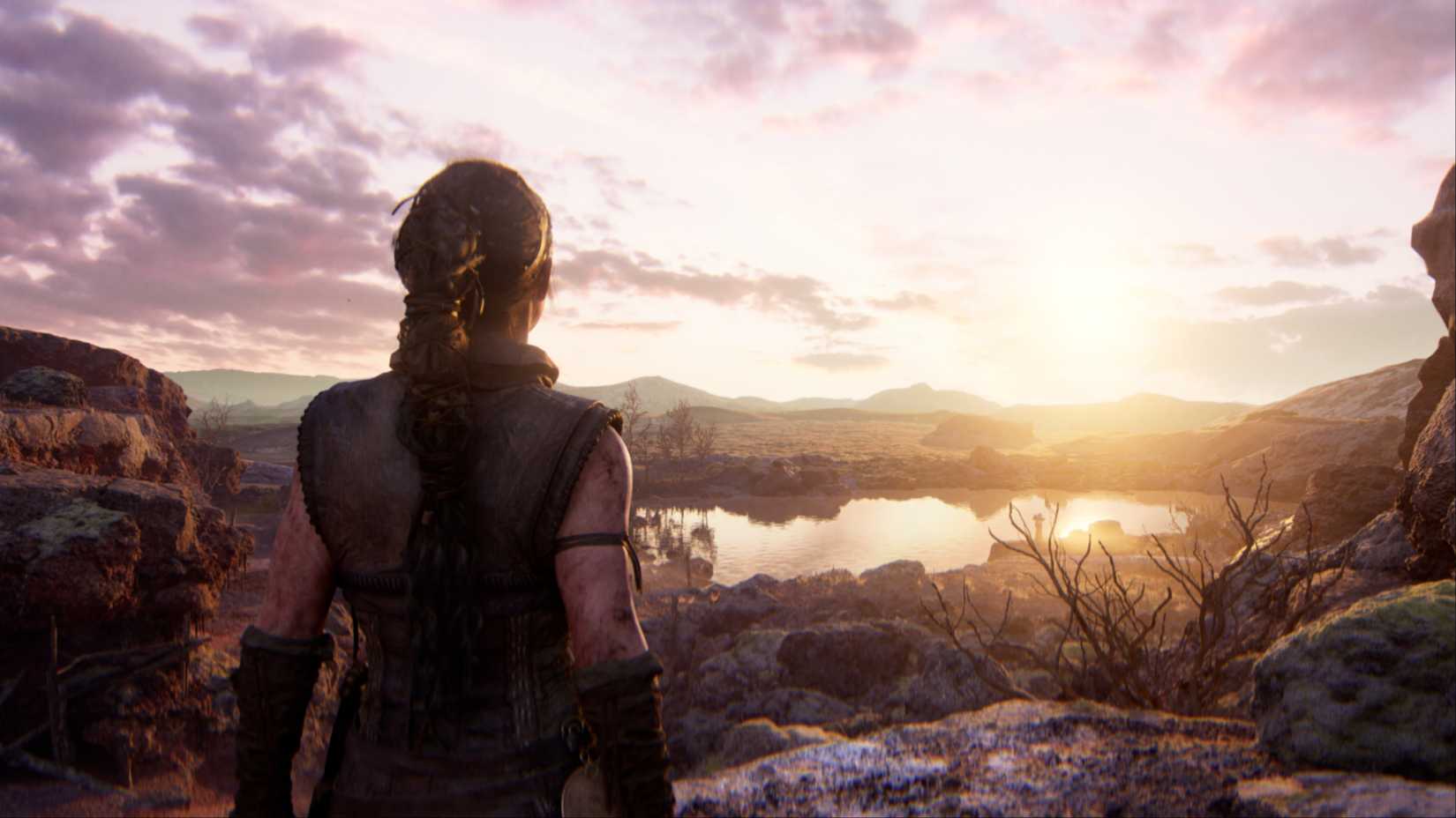 Senua approaching a large pond with the sunrise in Senua's Saga: Hellblade 2.