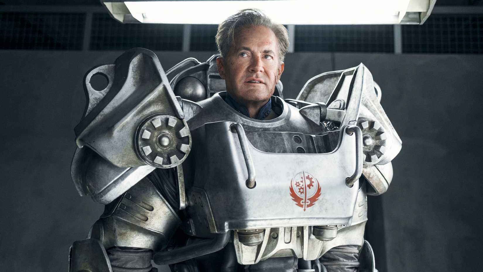 Fallout TV show Hank in power armor standing in front of a gray wall.