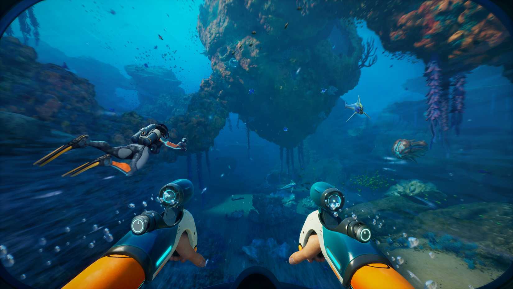 Players swimming together in the ocean, large rocks, and coral.