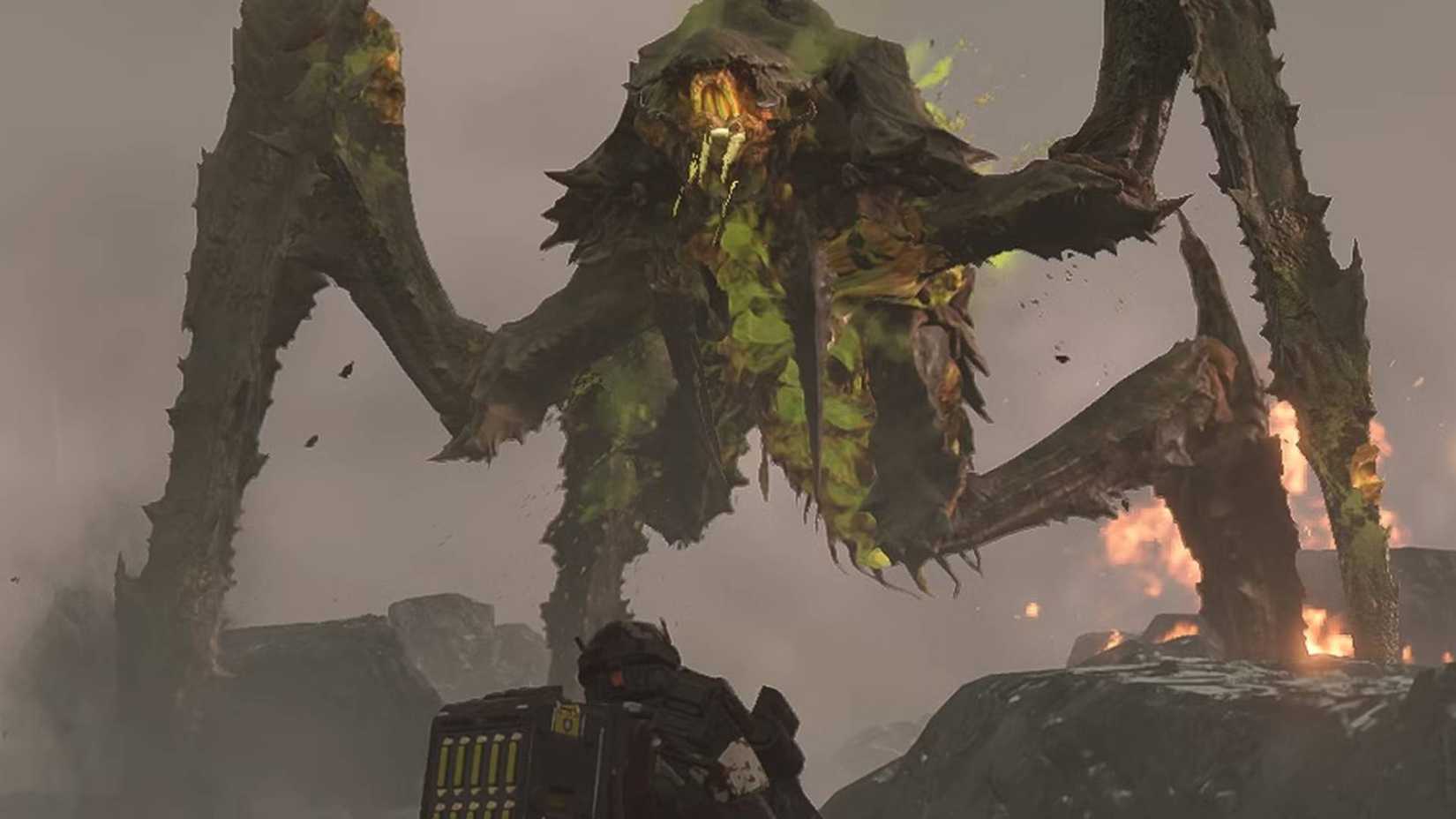 A Helldiver looking up at a Bile Titan in Helldivers 2.