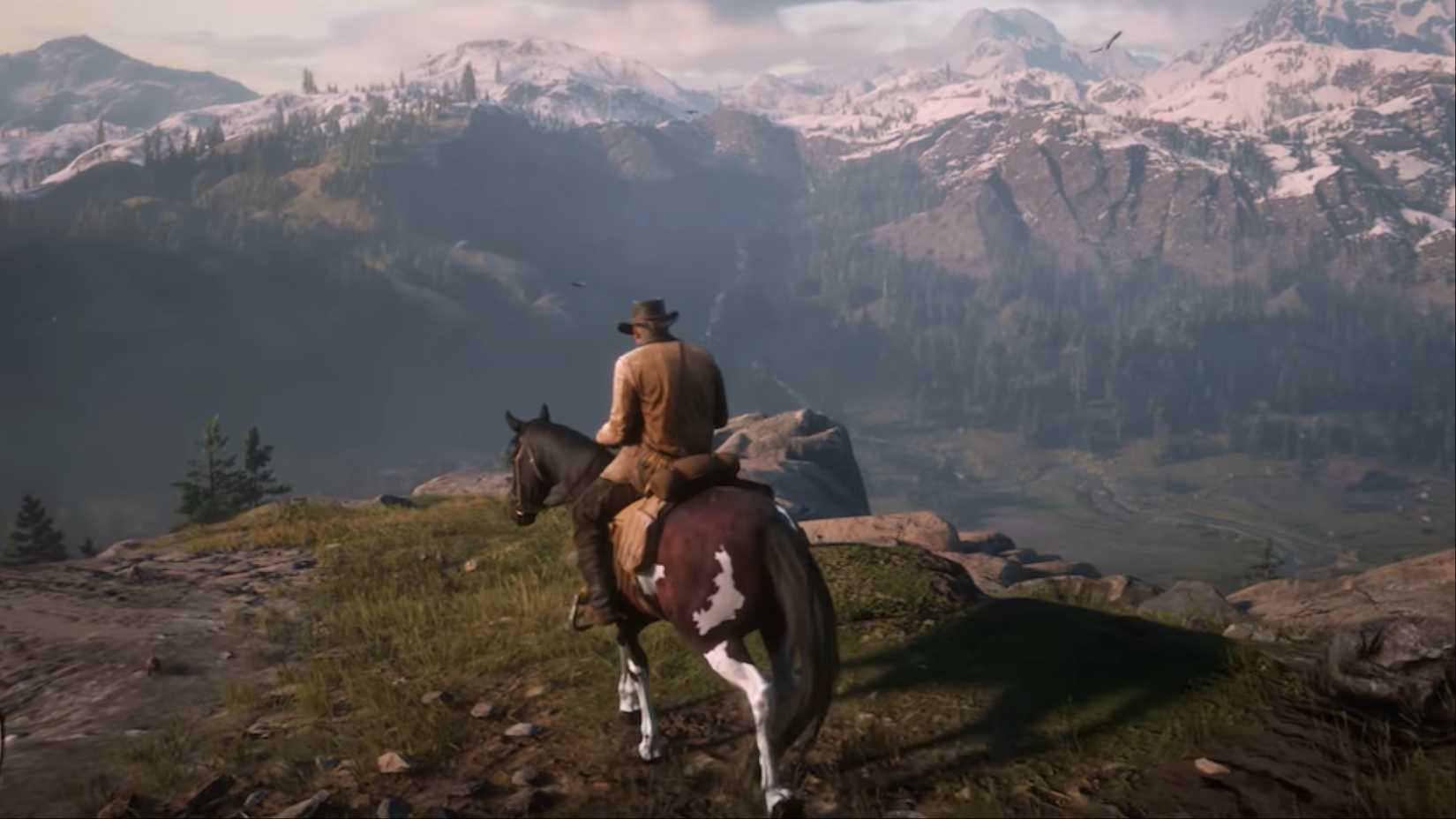 Arthur Morgan riding his horse on an elevated cliffside in Red Dead Redemption 2.