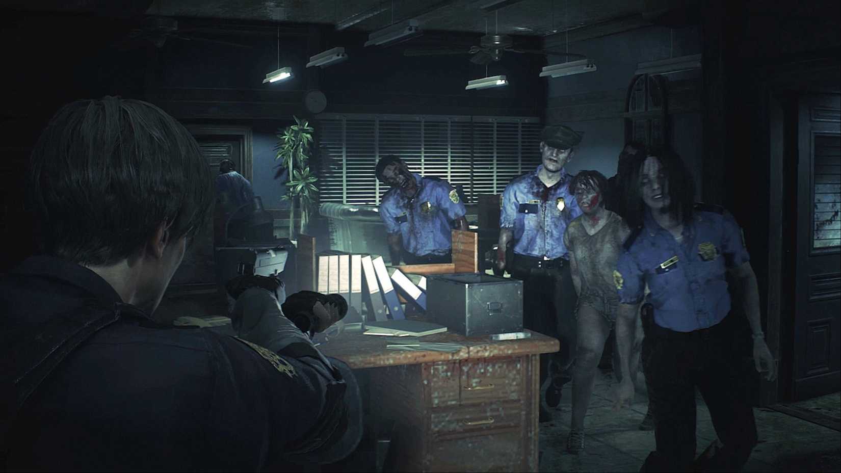 Leon Kennedy points his gun and flashlight at a crowd of zombies within the RPD in Resident Evil 2.