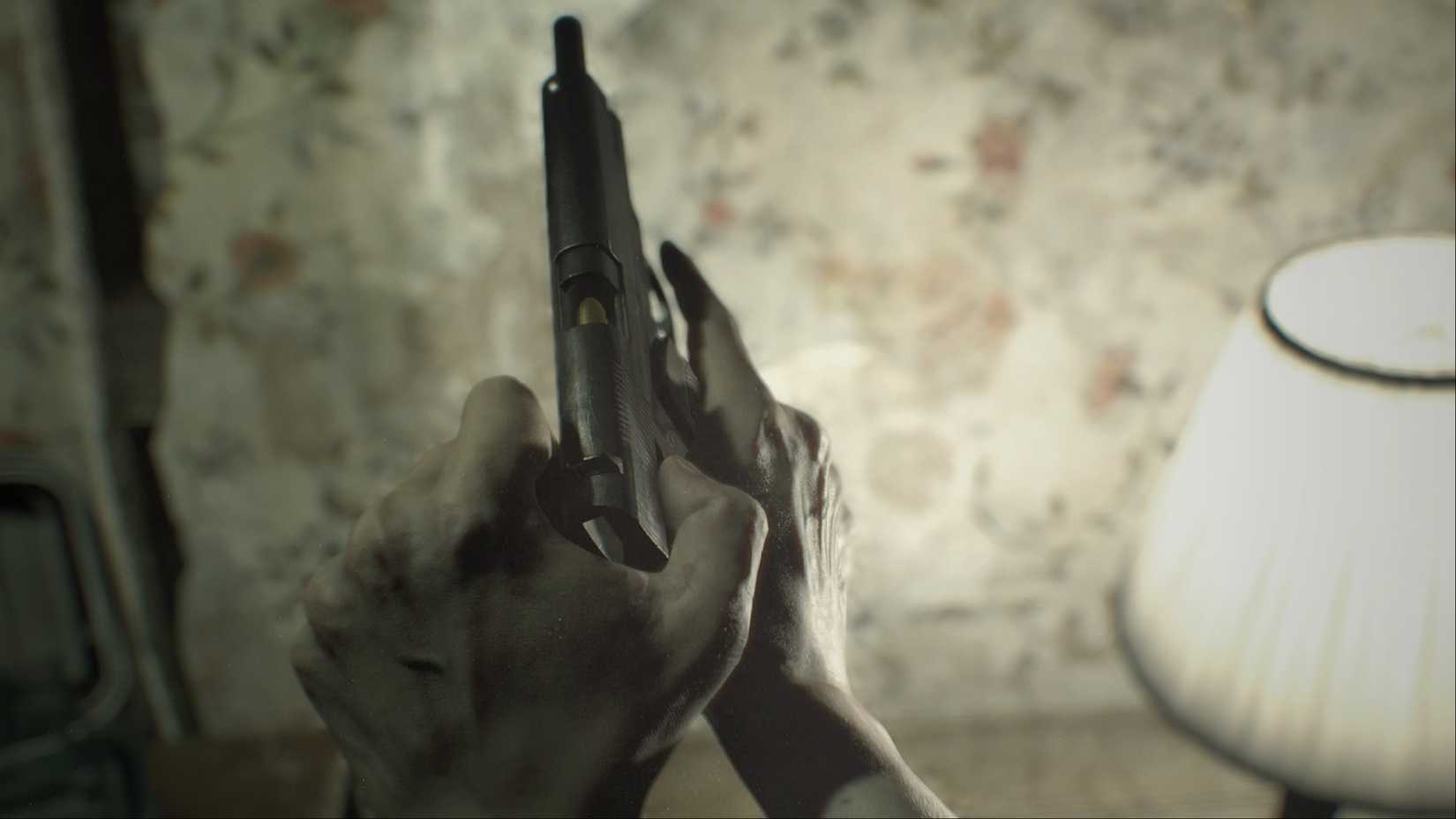 Ethan Winters checks the chamber of his gun in Resident Evil 7.
