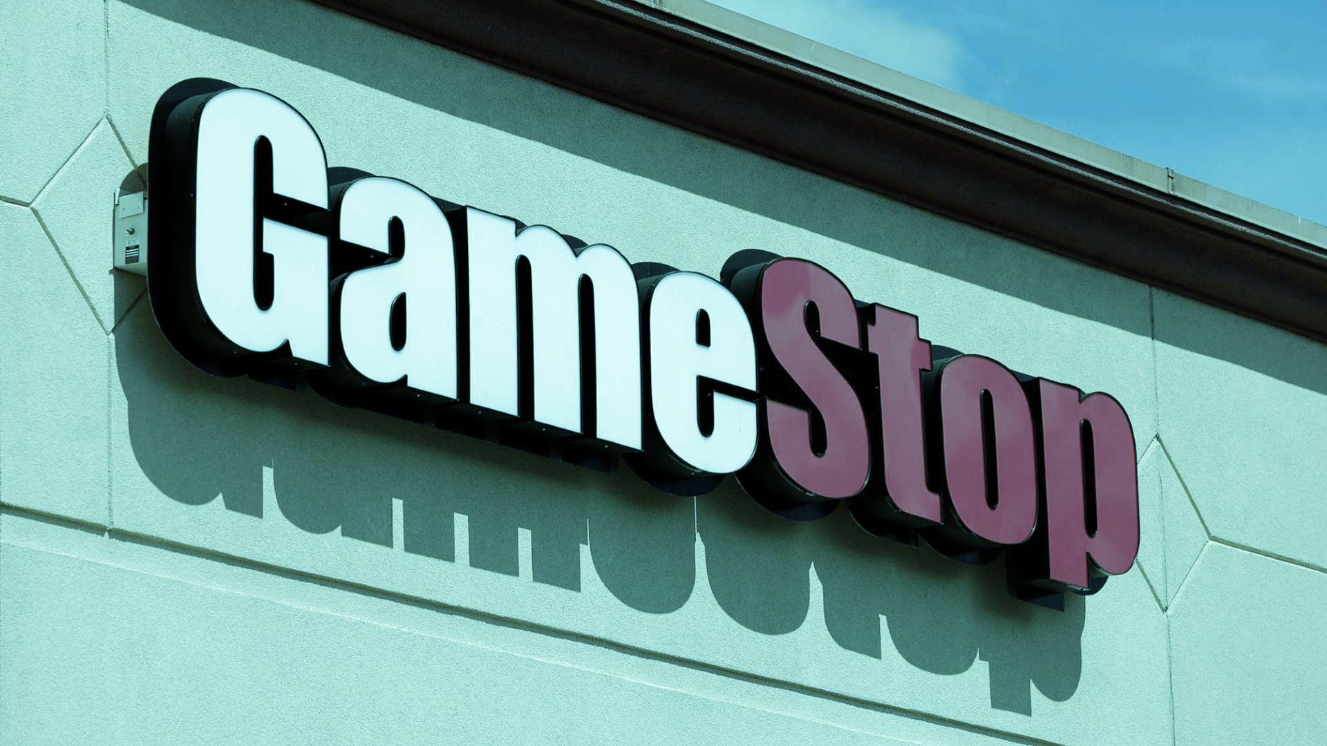 A photo of the GameStop logo in a blue colored shop.