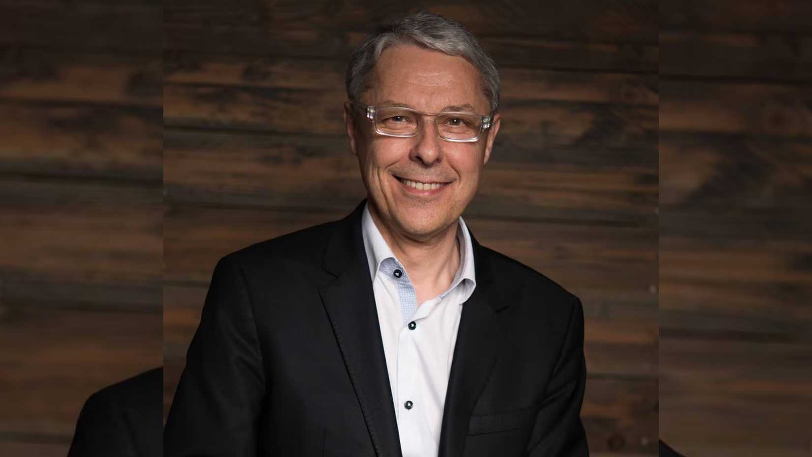 Portrait of Claude Guillemot on a wooden background.