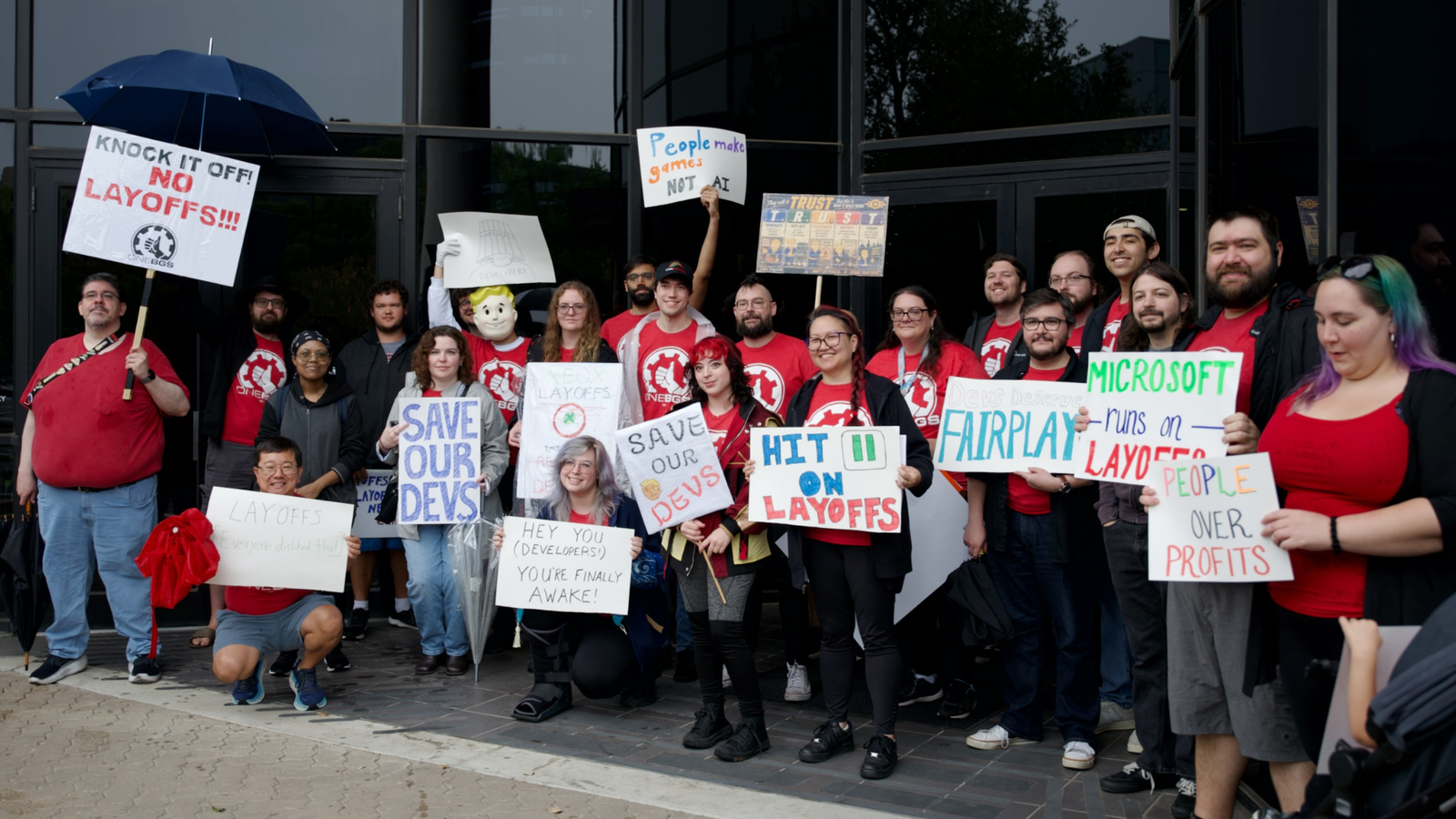 Cartelli e ironia contro Sharma: le proteste CWA davanti a sei sedi Xbox 3 A gathering of union members protesting outside an Xbox office holding various signs supporting workers.
