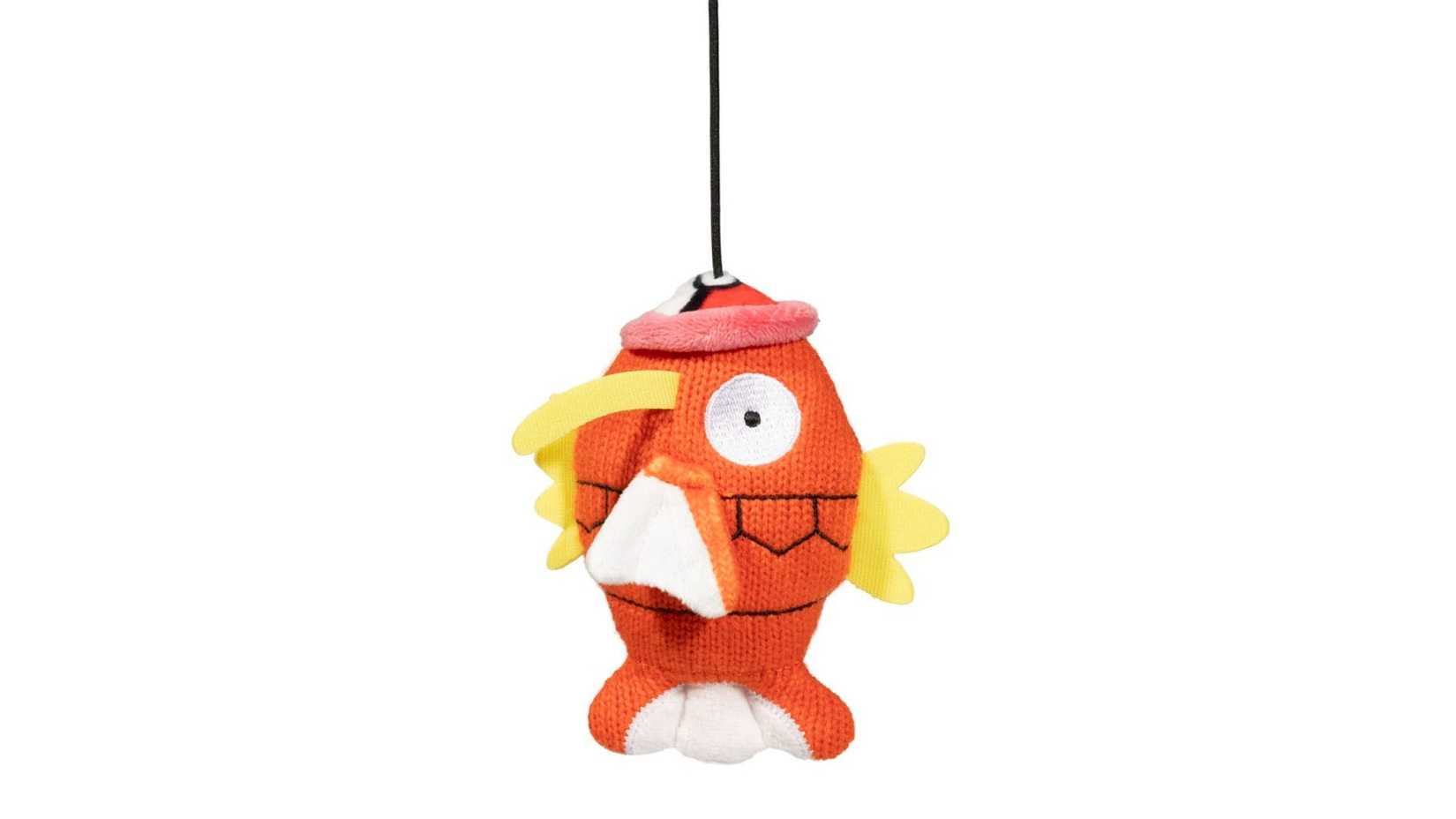 magikarp cat toy hanging from the top of the frame.