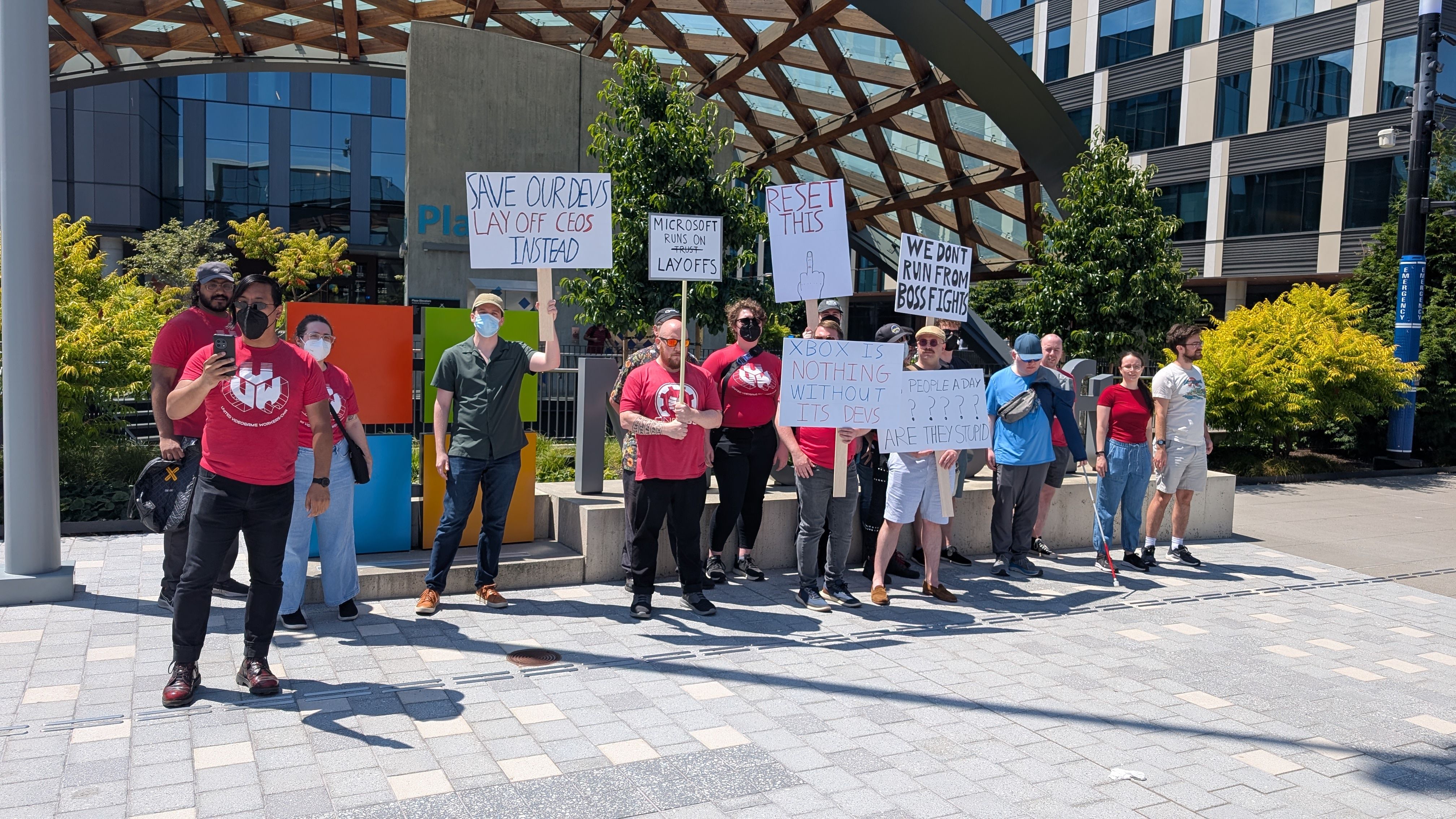A CWA protest outside of an Xbox studio with protesters holding sighs. 