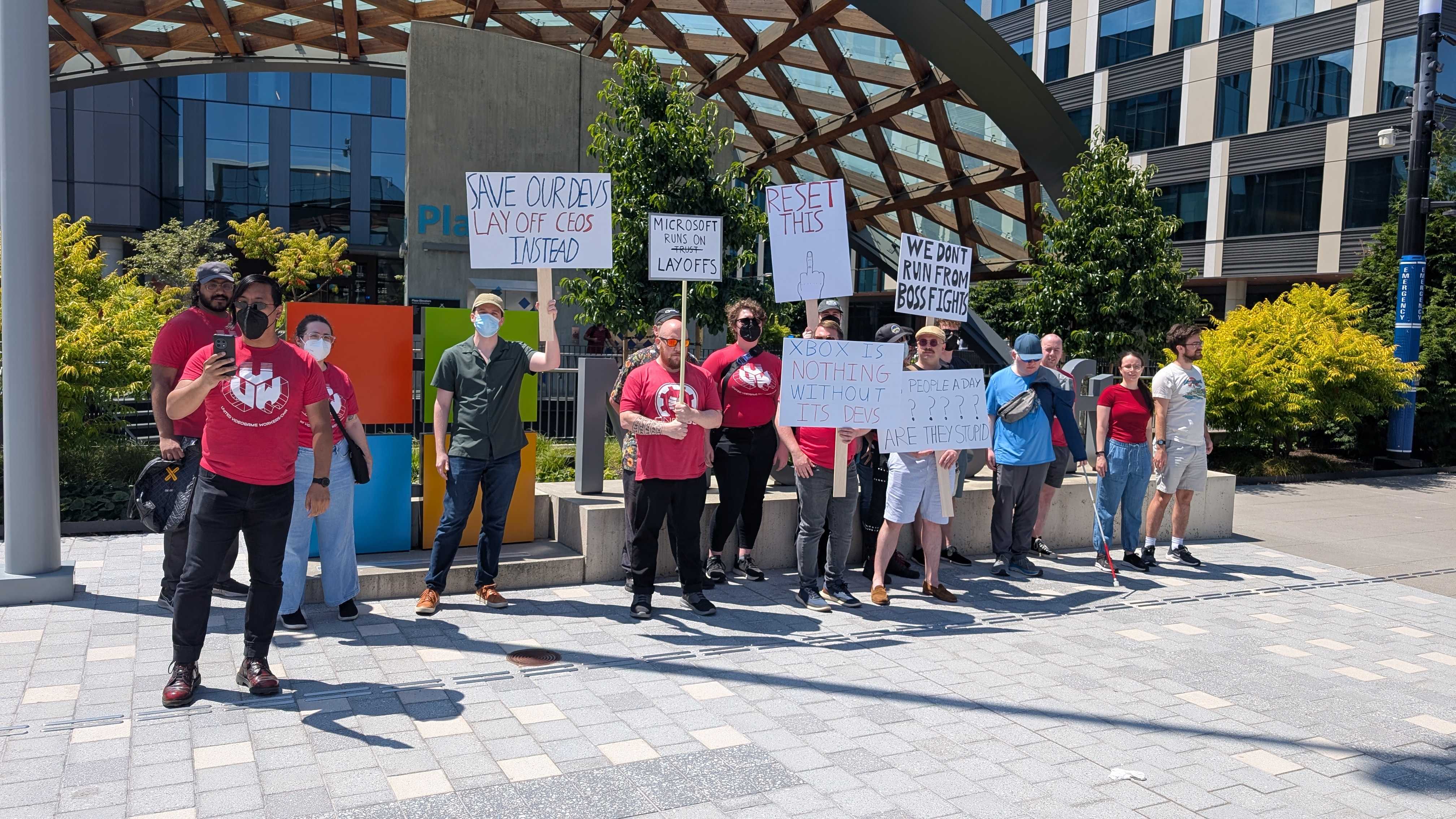 A CWA protest outside of an Xbox studio with protesters holding sighs.