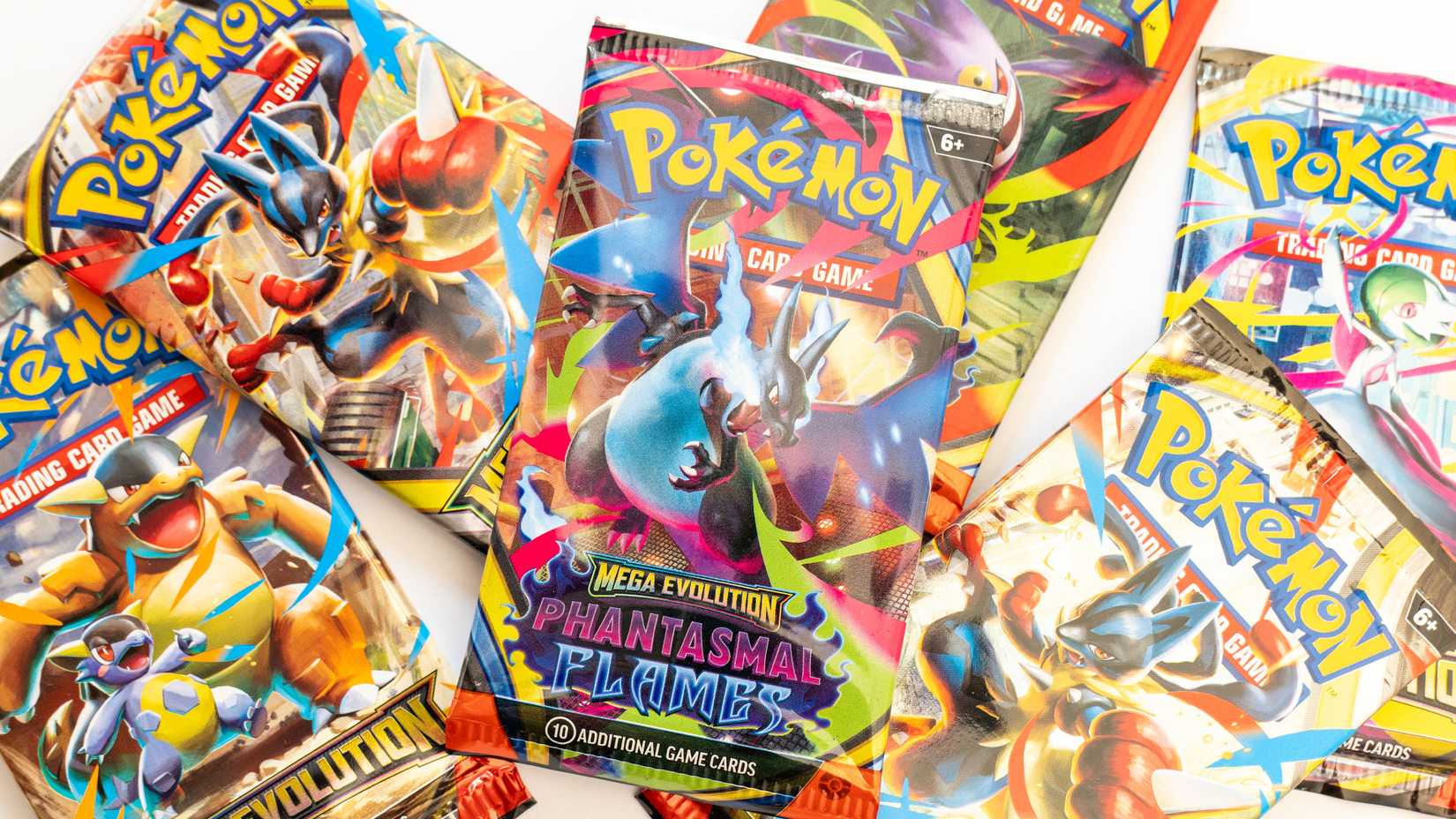STOCK Pokemon TCG packs scattered on a white table.