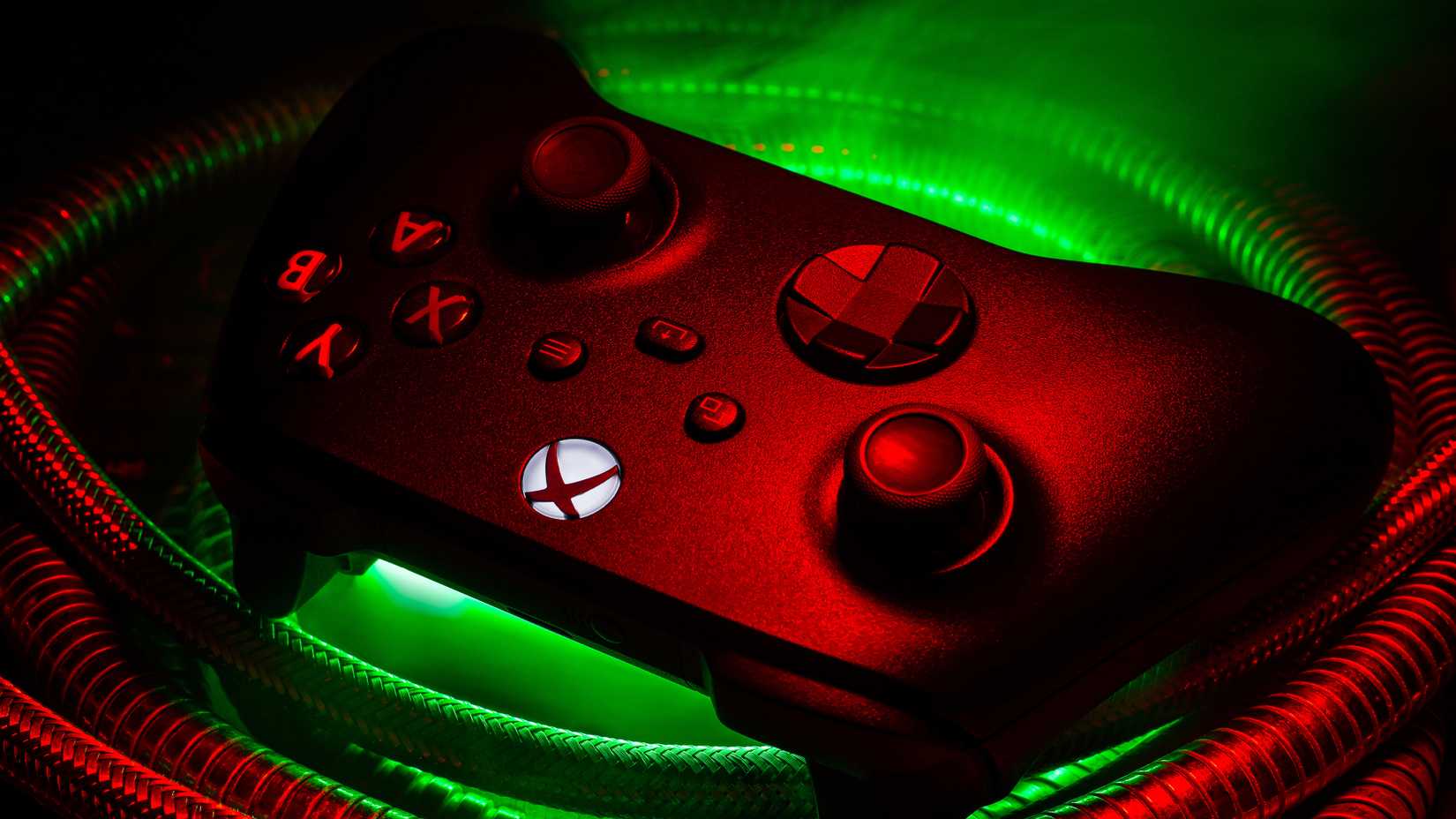 Xbox controller illuminated in red and green over a series of tubes.