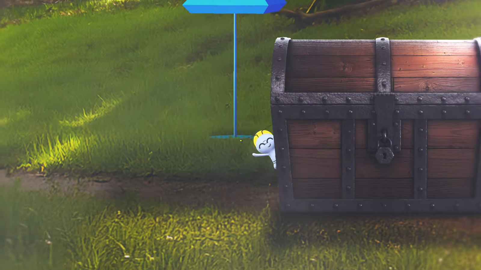 a gimmighoul poking out from behind a chest in front of a pokemon go pokestop.