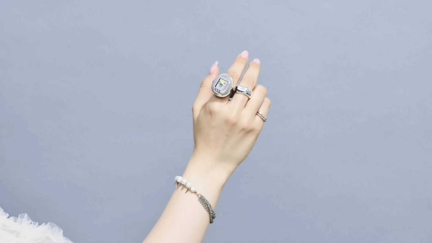someone wearing a tamagotchi ring.