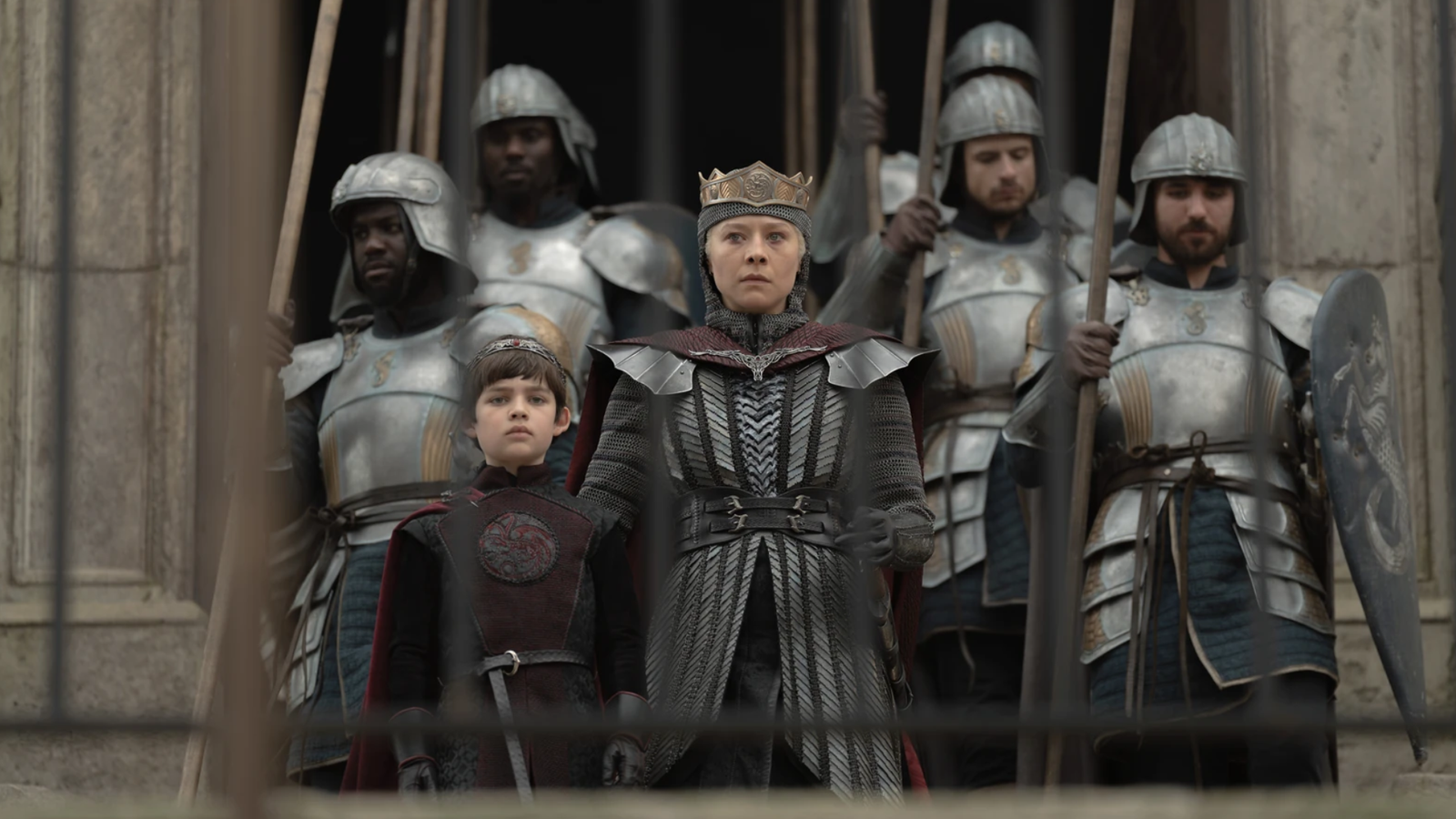Rhaenyra with her son Joffrey and several guards. Rhaenyra is wearing armour and a crown. 