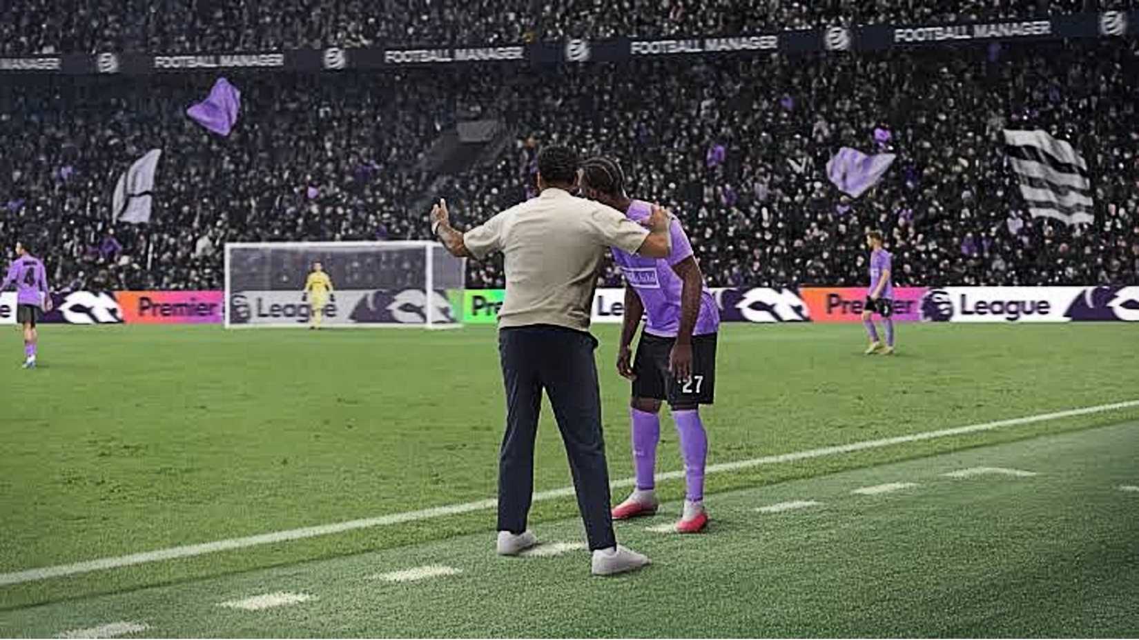 An image of a player and manager conferring on the sideline of a football pitch.