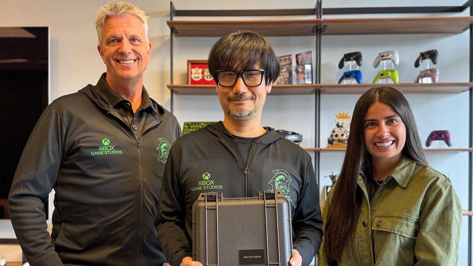 Hideo Kojima with Xbox CEOs wearing Kojima Productions and Xbox merchandise.