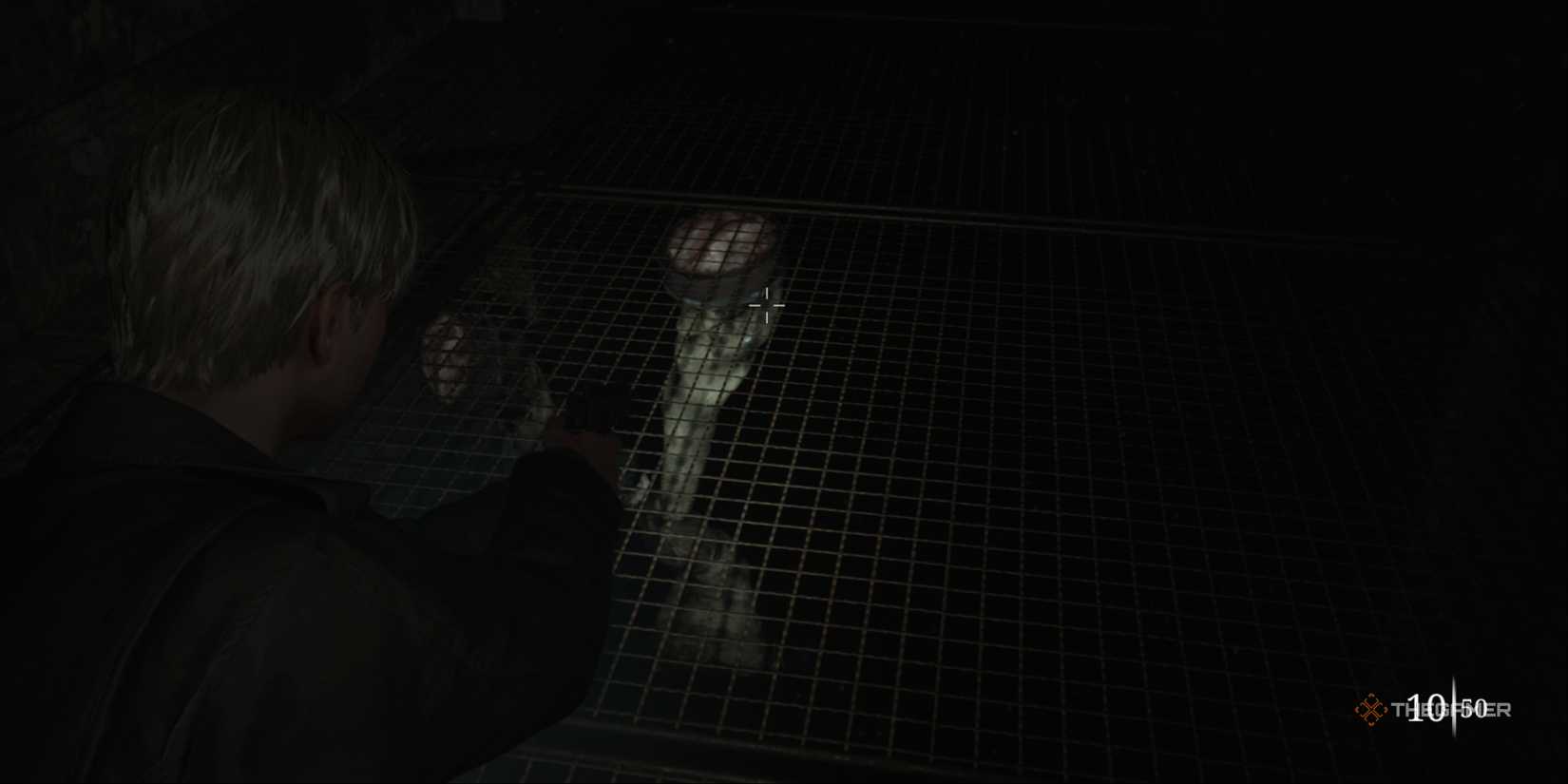 Silent Hill 2 - James aiming his gun at a Mandarin monster that's suctioning to the caged floor below him.