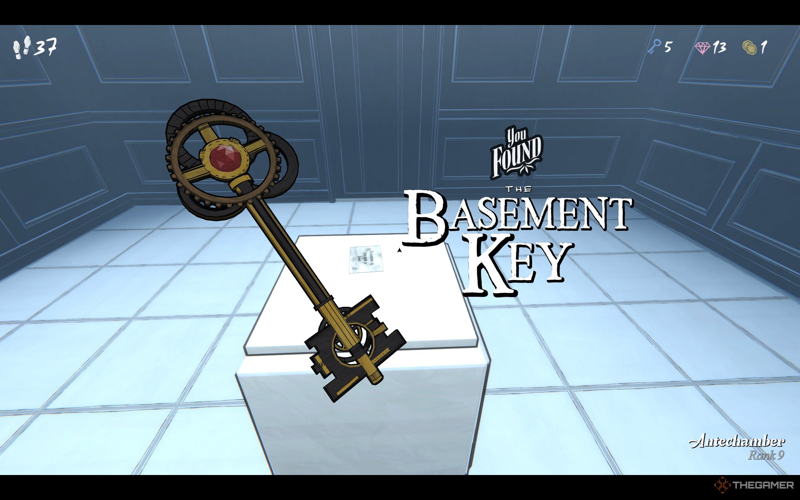A golden key with a ruby on top in Blue Prince&rsquo;s Antechamber.