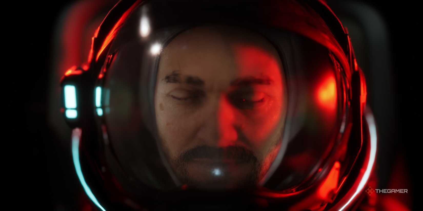 an extreme close-up of jan dolski in his space suit with the red glow of an emergency light in the opening sequence of alters.